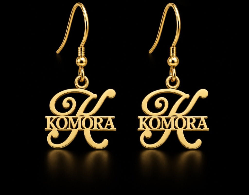 Boucles d’oreilles KOMORA dorées personnalisées avec grande initiale K et prénom Komora fond noir