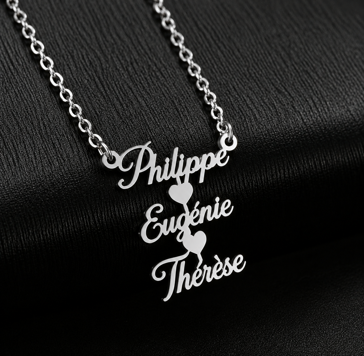 
Collier FRATRIE argenté personnalisé avec trois prénoms Philippe Eugénie et Thérèse porté par une femme FOND NOIR 