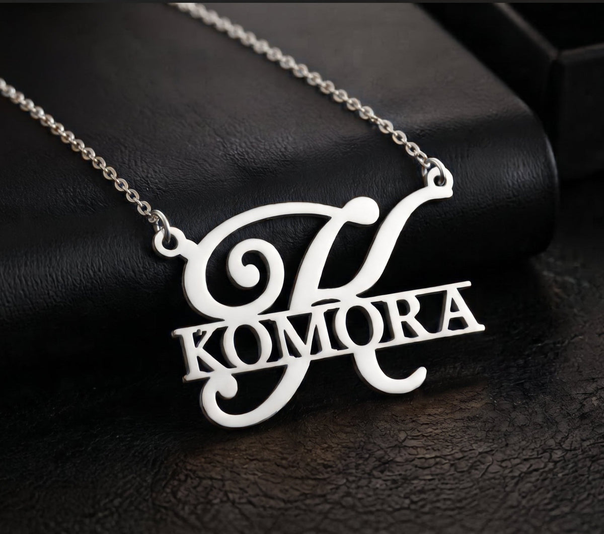 Pendentif initiale et prénom KOMORA Argenté sur fond noir