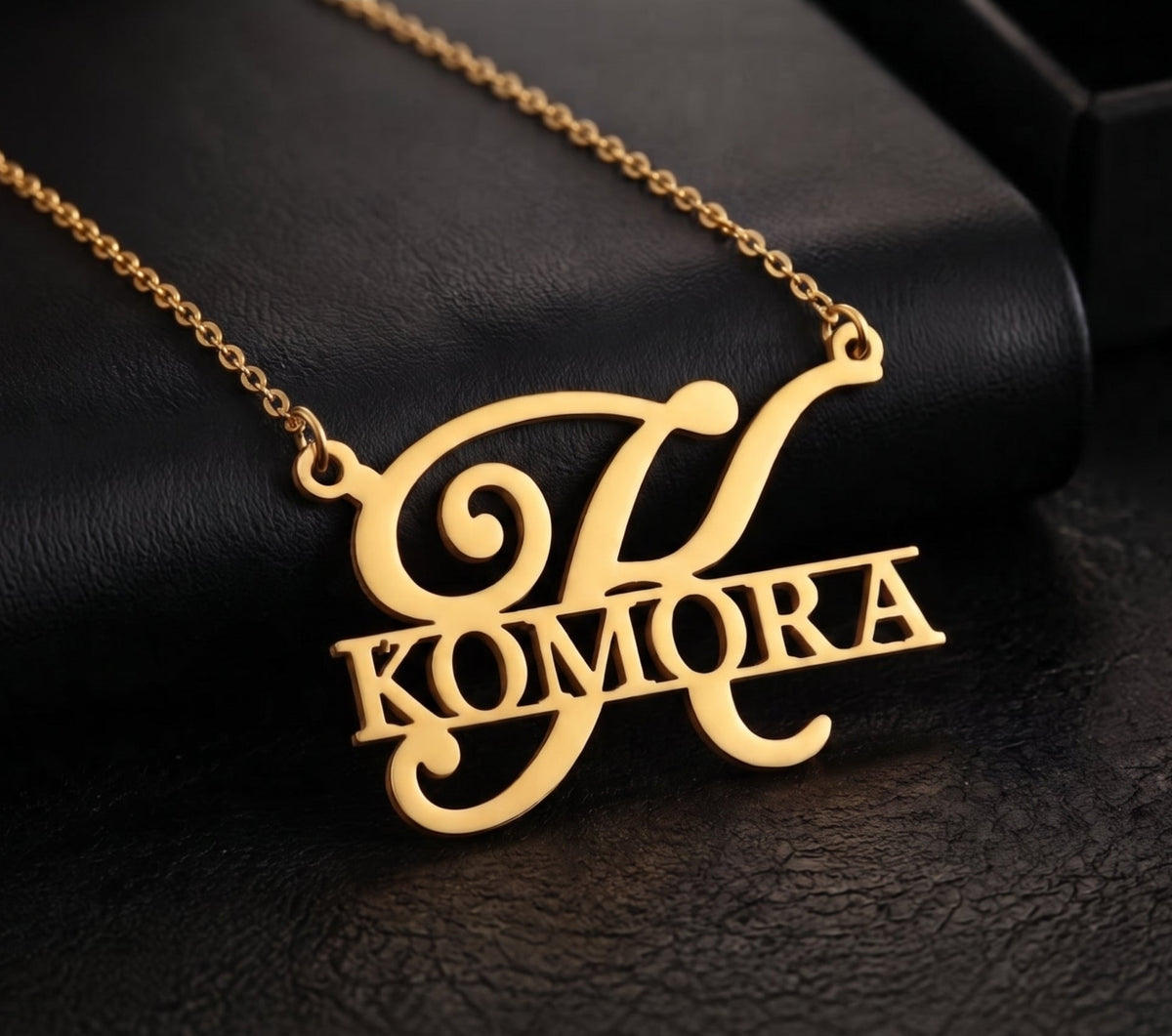 Pendentif initiale et prénom KOMORA doré sur fond noir
