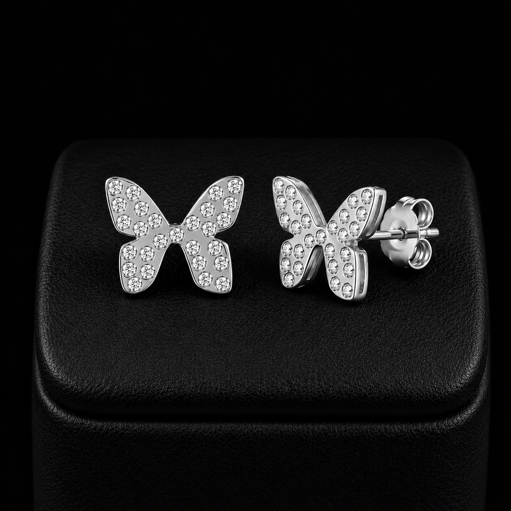 Boucles d’oreilles papillon enfant argenté avec pierres scintillantes fond noir