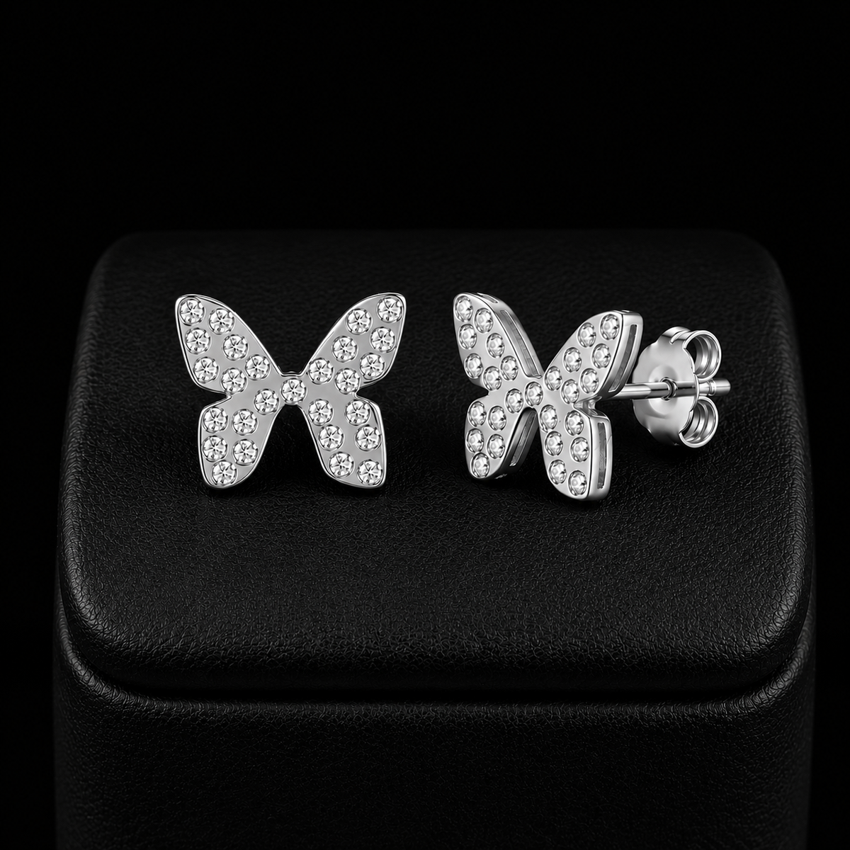 Boucles d’oreilles papillon enfant argenté avec pierres scintillantes fond noir