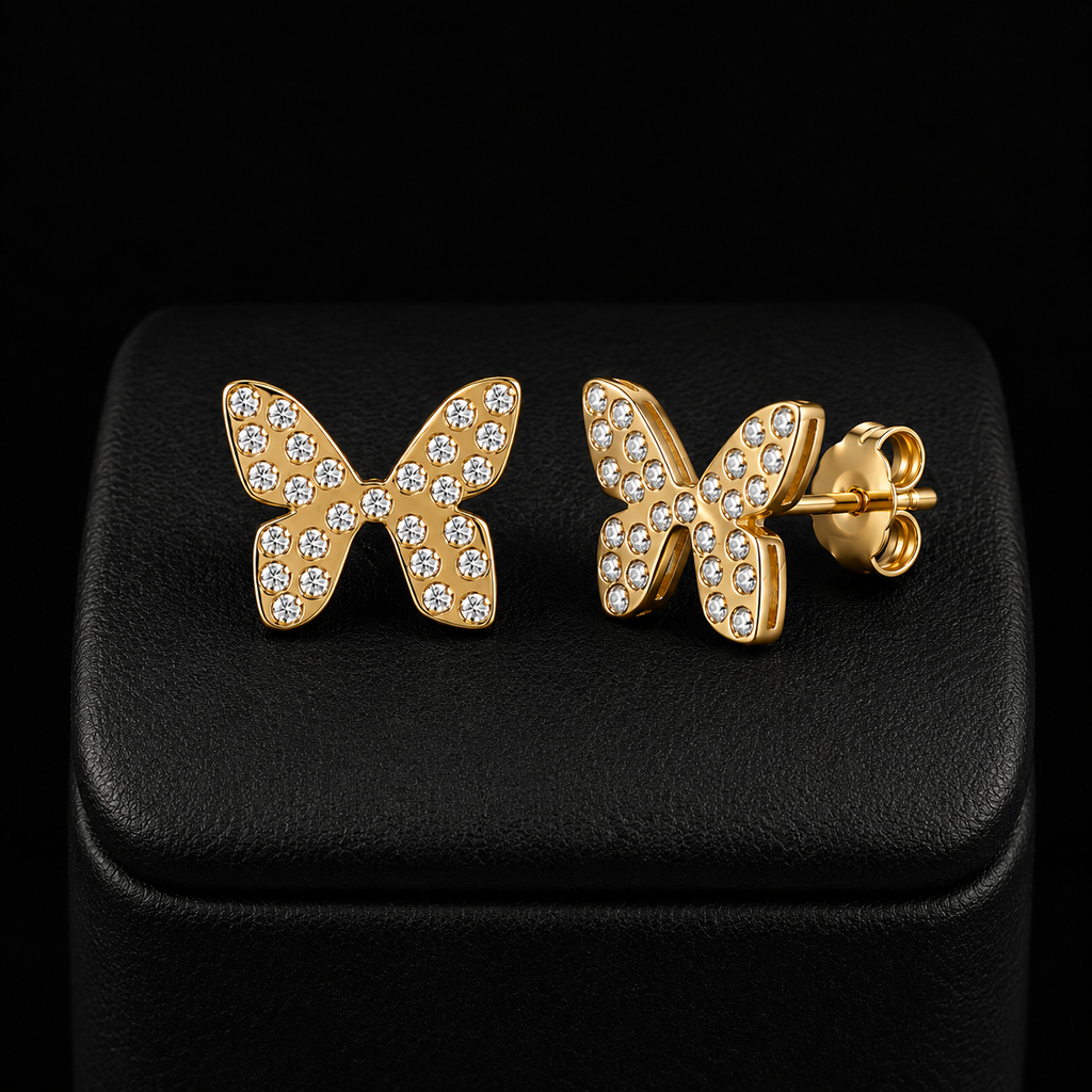 Boucles d’oreilles papillon enfant dorées avec pierres scintillantes fond noir