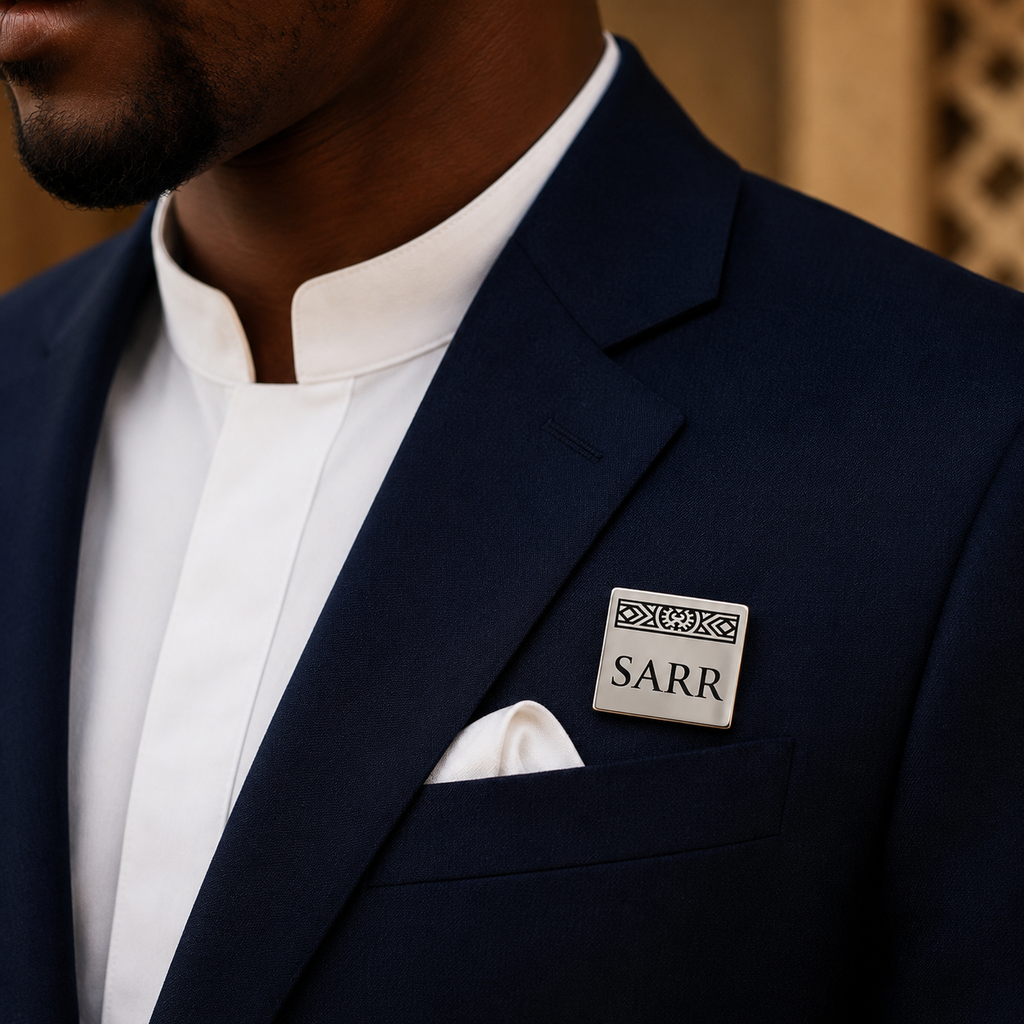 Pin's personnalisé LIGNÉE argenté porté sur costume bleu