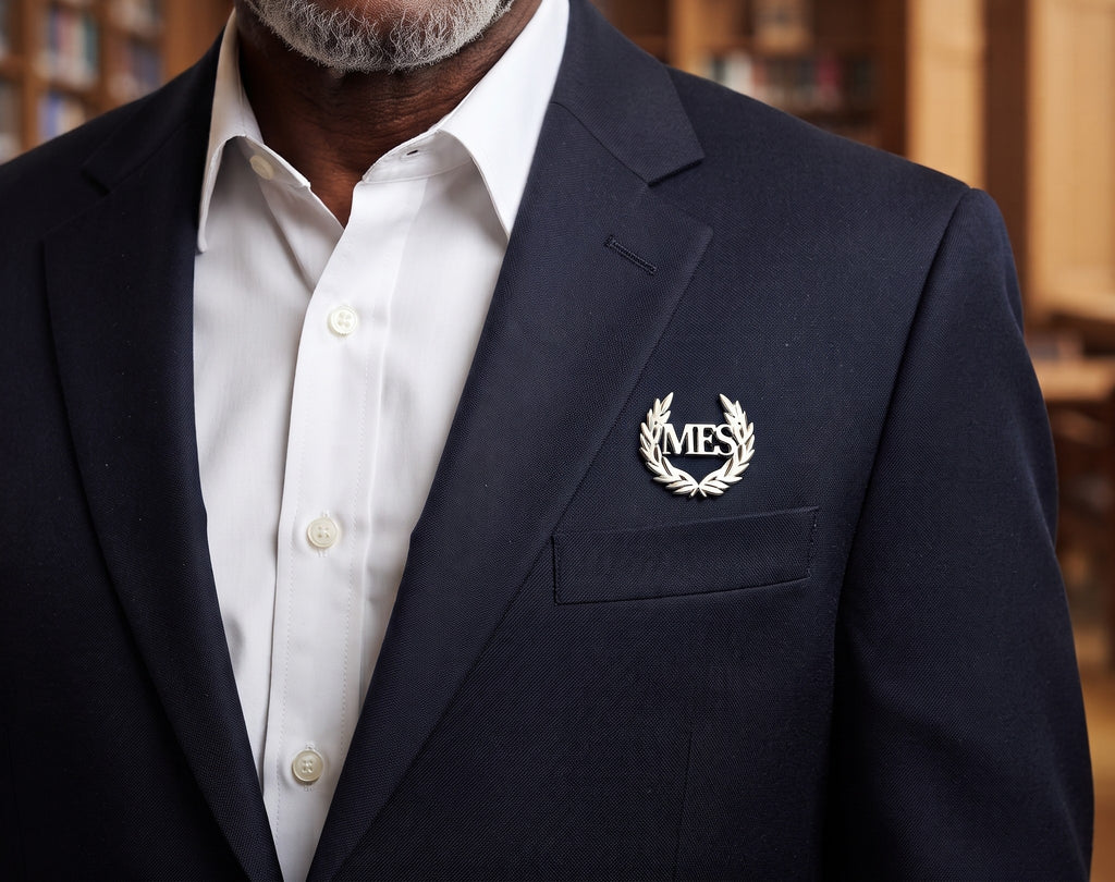Pin’s LAURIER argenté personnalisé avec les initiales MFS et couronne de laurier porté sur une veste
